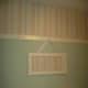 A chair rail can be installed 24-30 inches from the ceiling for a different look. In this bedroom, wallpaper was used above the rail, and paint was used below. Pegs were added to the rail for a little something extra.