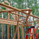 Use a makeshift pole to rotate the trusses upwards and lean them into place.