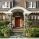 Exquisite stone example with covered front porch, wood shutters, and windows with mullions.
