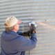 An angle grinder is used to remove stubborn bolt heads on this 1940s era grain bin which is to be moved.