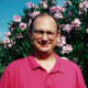 My hubby standing against our pink oleanders