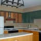 BEFORE: Cabinets were mix of painted and natural wood. Some hardware missing and mismatched. Stove hood copper colored.