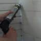 Example showing how to caulk in corners while sealing a home.