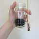 Add moistened soil to your bottle or jar. Use a chopstick or pencil to keep it off the walls of the jar.