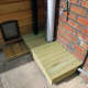 Decking planter platform and cat step used to hide downpipe from conservatory to drain.