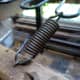 Spring reattached to the chair; having made a new loop by pulling out the end of one of the coils from the spring.