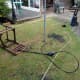 Pressure washer and chair on lawn, with pressure washer attached to outside tap.