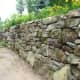 These mossy stones make a new wall in Bromont, QC look as though it has been around for a hundred years. These stones replaced an earlier wall built with stones too small to hold back the bank.