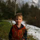 My six year old son holds Forsythia branches: we will bring these indoors to force a bloom.