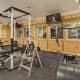 A rustic home gym with with plywood walls and dark grey flooring