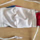 I stretched a strip of t-shirt fabric to make a cord then, using a safety pin, brought the cord up from the bottom of one side, then down through the top of the other side. Alternatively, two smaller cords could be cut to make 2 ties.