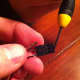 With a small screwdriver, gently release the tab holding the wires in place.
