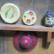 Shelf, plates, jug, painted designs on plates and jug. Hat with brim, ribbon on hat.