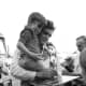 Johnny Cash holding a child with a concho belt wrapped over his shoulder