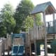 More play equipment made of natural and artificial materials, located in a semi-natural playground in a park
