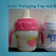 An Avent training cup next to an Avent newborn bottle.