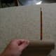 Use a pencil to make a hole halfway down the length of the cardboard tube.