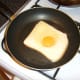 The egg is fried on top of the bread