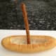 2. Insert a large pretzel stick in the center of the bread boat and twist base into bread so that it stays in position as the mast.