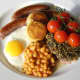 The baked beans are spooned on to the plate, the mushrooms are added and this full Welsh breakfast is ready for the table.