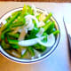 Slice a green pepper and half of an onion into thin strips.