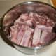 After cutting the rack of ribs into individual ribs or into quarters, place the ribs into a pot.