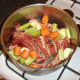 Vegetables and seasonings are added to beef and bones