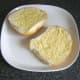 Bread roll is spread with Dijon mustard