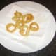 Onion rings are drained on kitchen paper