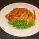 Garden peas are served with the sea bream fillets and chips