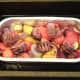 Chopped kangaroo meat is added to tray with roasted vegetables