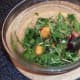 Peach and salad leaves are added to bowl with marinade