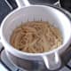 Spaghetti is drained through a colander