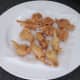 Battered frogs' legs are drained on kitchen paper