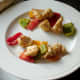 Grilled vegetable pieces are removed from skewers