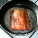 Salmon is added to frying pan