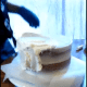 Start smoothing around the sides and top, giving an even layer all the way around the entire cake.