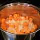 After melting butter, add the chopped carrots and onions. 