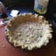 The pie crust, after being worked to cover the pie dish and its edges fluted. 