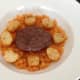Burger and potatoes are arranged on carrot bed