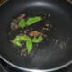 8. Heat oil in a deep-bottomed pan. Add cumin seeds and curry leaves. Saute them till they sizzle.