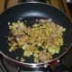 Heat oil in a deep-bottomed pan or wok. Throw in the mustard seeds and let them crackle. Add white lentils and saut&eacute; for 30 seconds. Throw in the grated ginger, chopped onions, and turmeric powder.