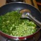Step three: Add fresh peas, chopped fresh green coriander, and chopped capsicum. Saute on a low fire for two minutes.