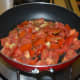 Step four: In the same pan, add chopped tomatoes. Stir-cook on a high heat for 4 minutes. Add cooked carrots. Mix well. Turn off the heat. Transfer it to the same mixer/blender in which you have collected the sauteed spices.