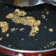 Step six: Heat 1 teaspoon oil in a small pan. Throw in chopped garlic and sesame seeds. Saute until they become golden brown.