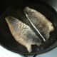 Sea bass fillets are turned in the pan.