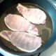 Bacon is added to hot frying pan