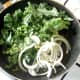 Kale and onion are added to the pan of pork juices and seasoned.