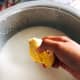 In a large pan, combine the coconut milk and durian flesh into the pan. Use your hand to remove the durian flesh from the seed.