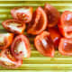 Quarter each tomato and remove the seeds. This is done easily by placing the tip of the knife at the bottom and running it under the seeds towards the stem end with the knife parallel to the tomato.